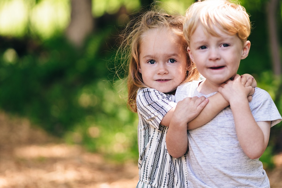 Brother and sister twins hug during Minnesota family video session.