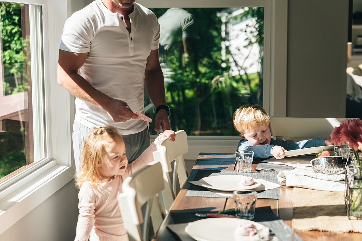 Three year old twins help set the table during a Minnesota family video.