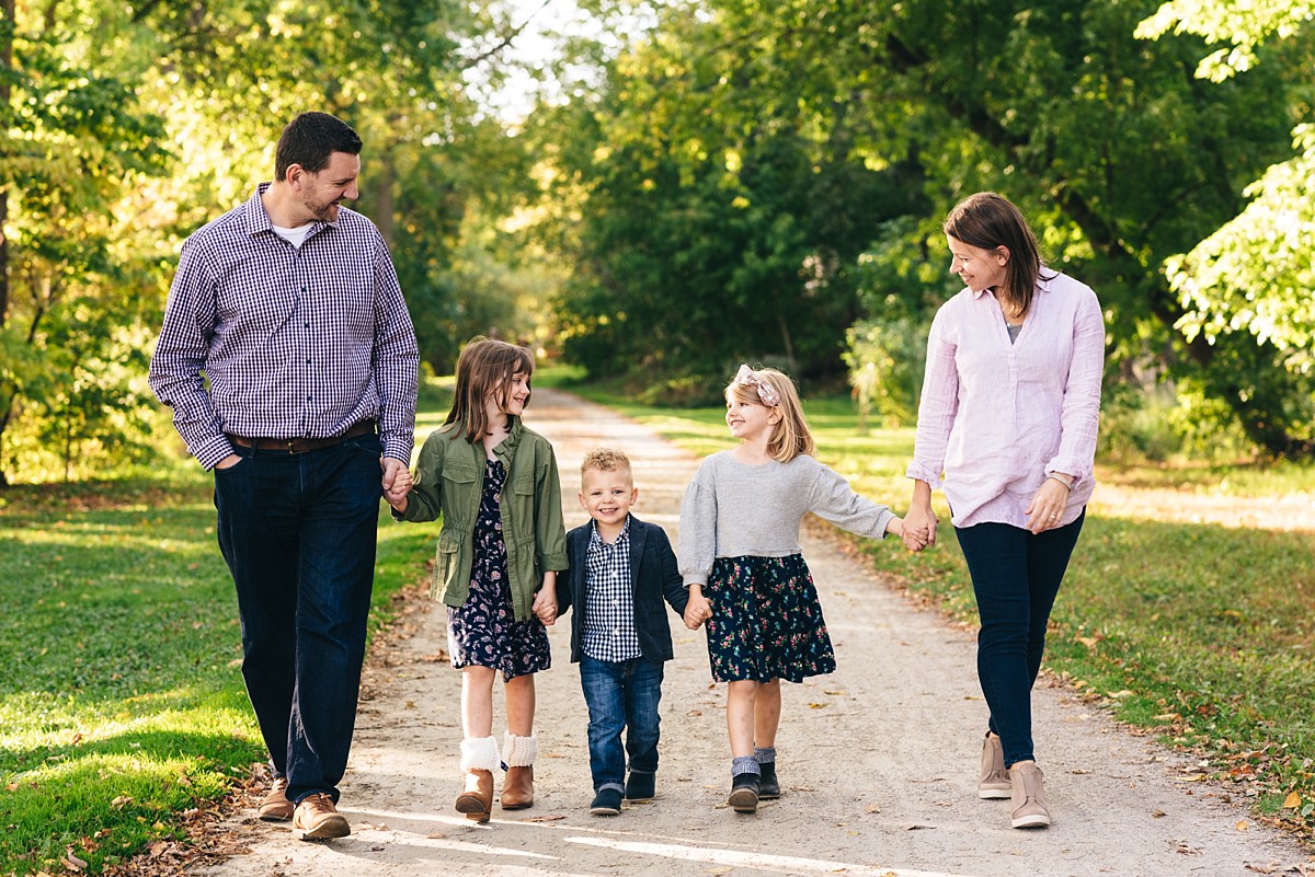 Minnesota family holds hands and walks together during a sunset photography session.