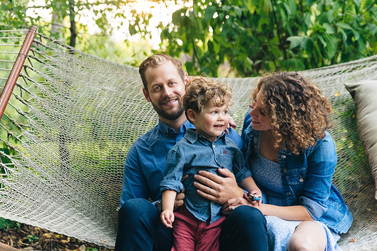 Family sits in hammock.