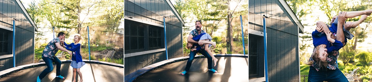 Father and daughter laugh and jump on a trampoline.