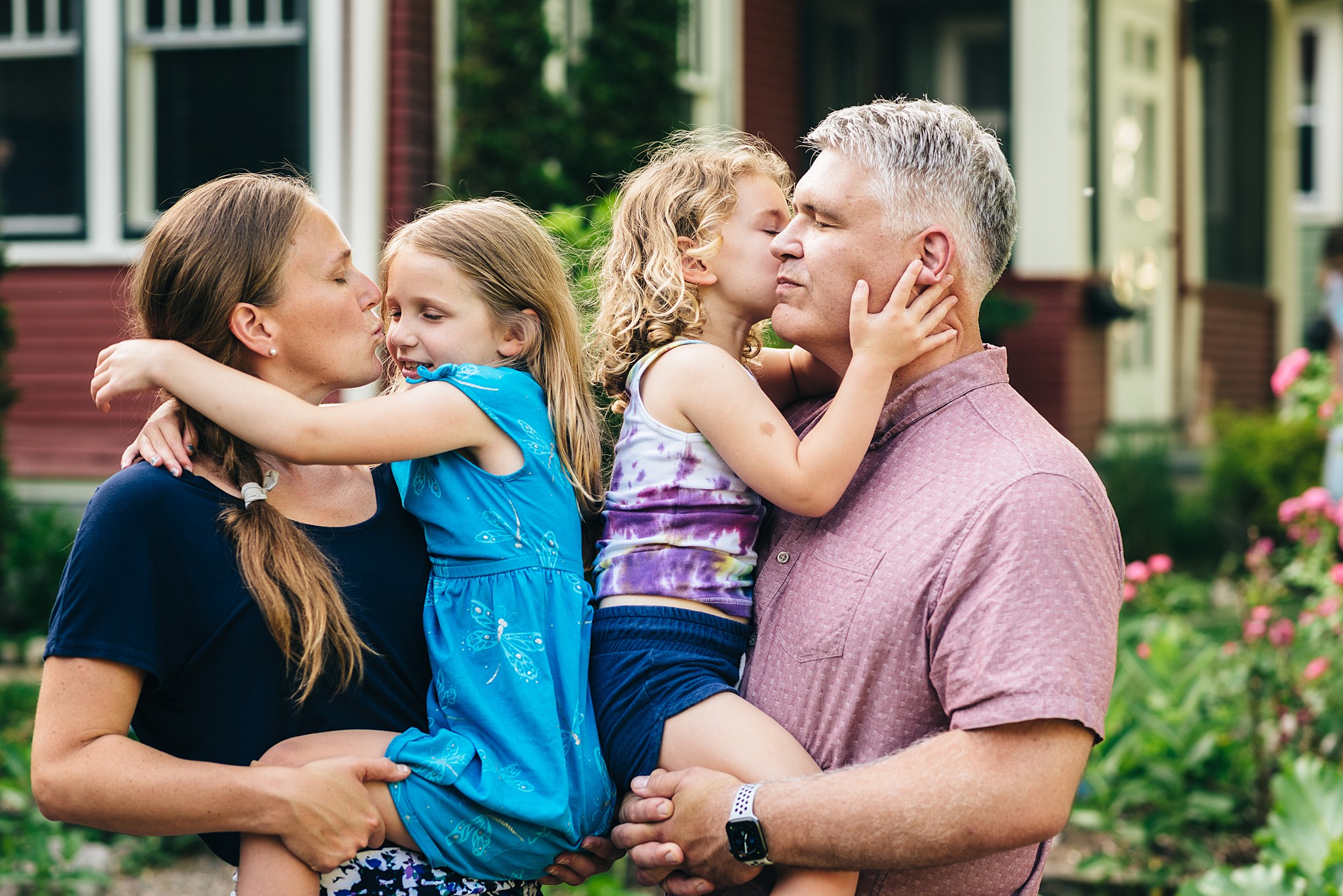 Family kisses each other for photo.