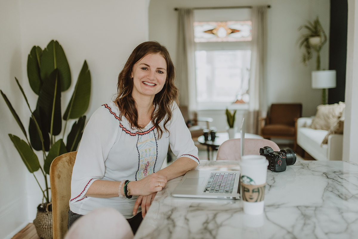 5 Tips for using a branding film on a website. Woman sits at table with laptop.