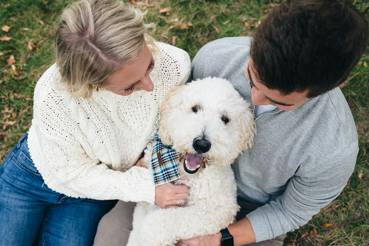 Couple and their dog. Dog looking up at camera.