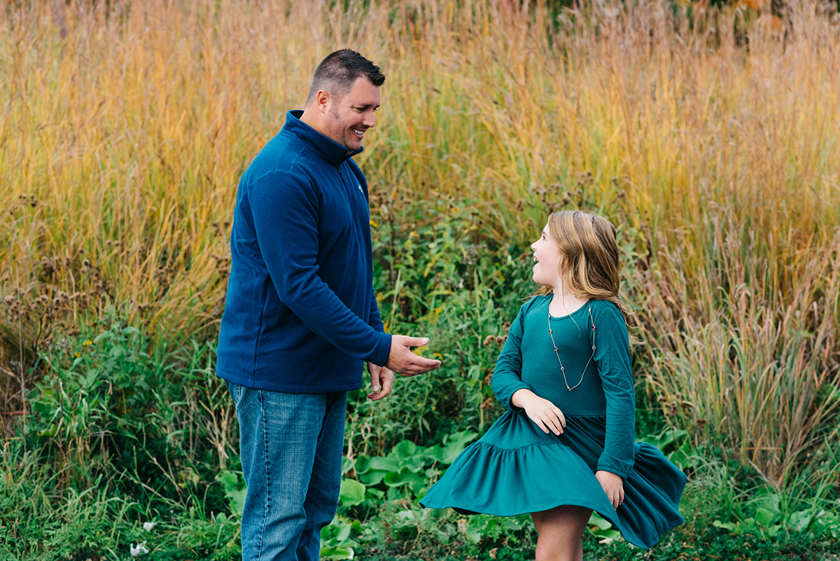 Father spins daughter in a circle during sunset sessions.