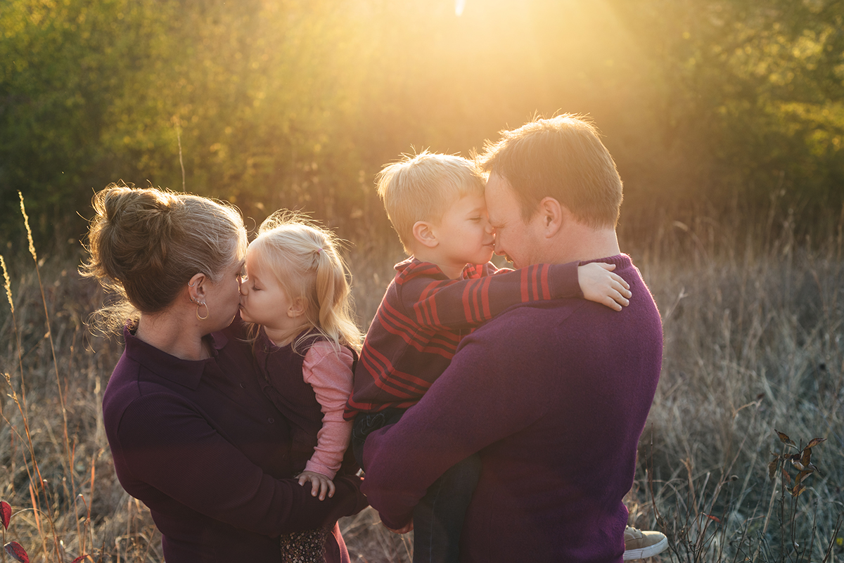 Family snuggle in the sunset session light.