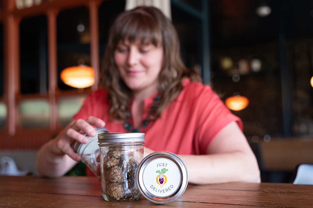 Elysse Voyer of Just Delivered LLC sits with some of the products she offers in the foreground during Flagstaff branding sessions at High Country Motor Lodge.