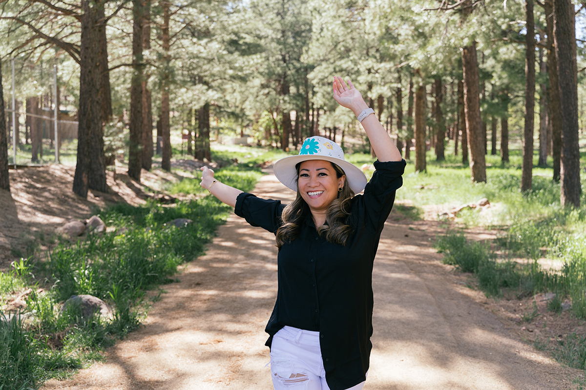 Woman dances toward the camera in the woods.