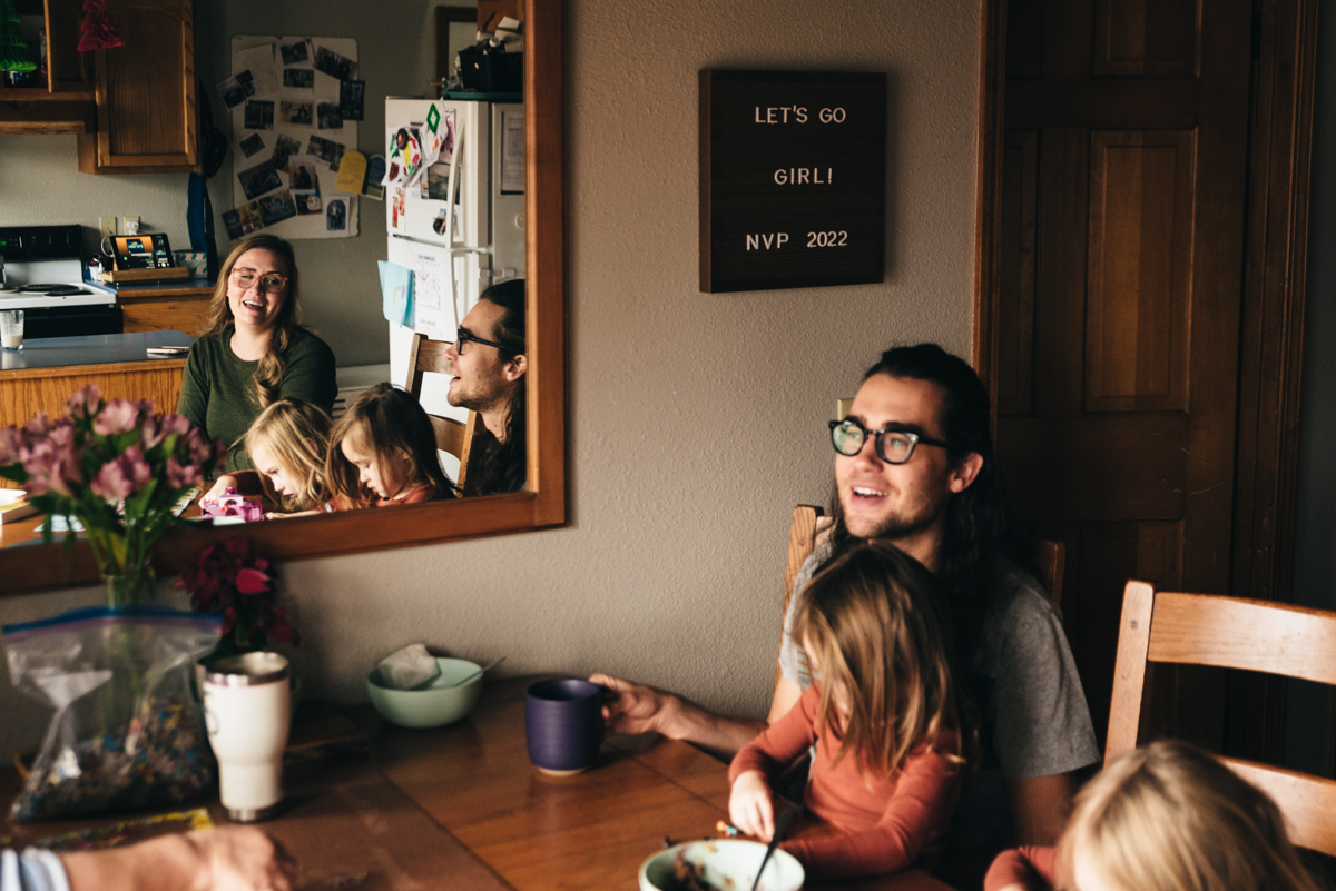 Stoff family sits in kitchen. Image of the family in reflection of a mirror.