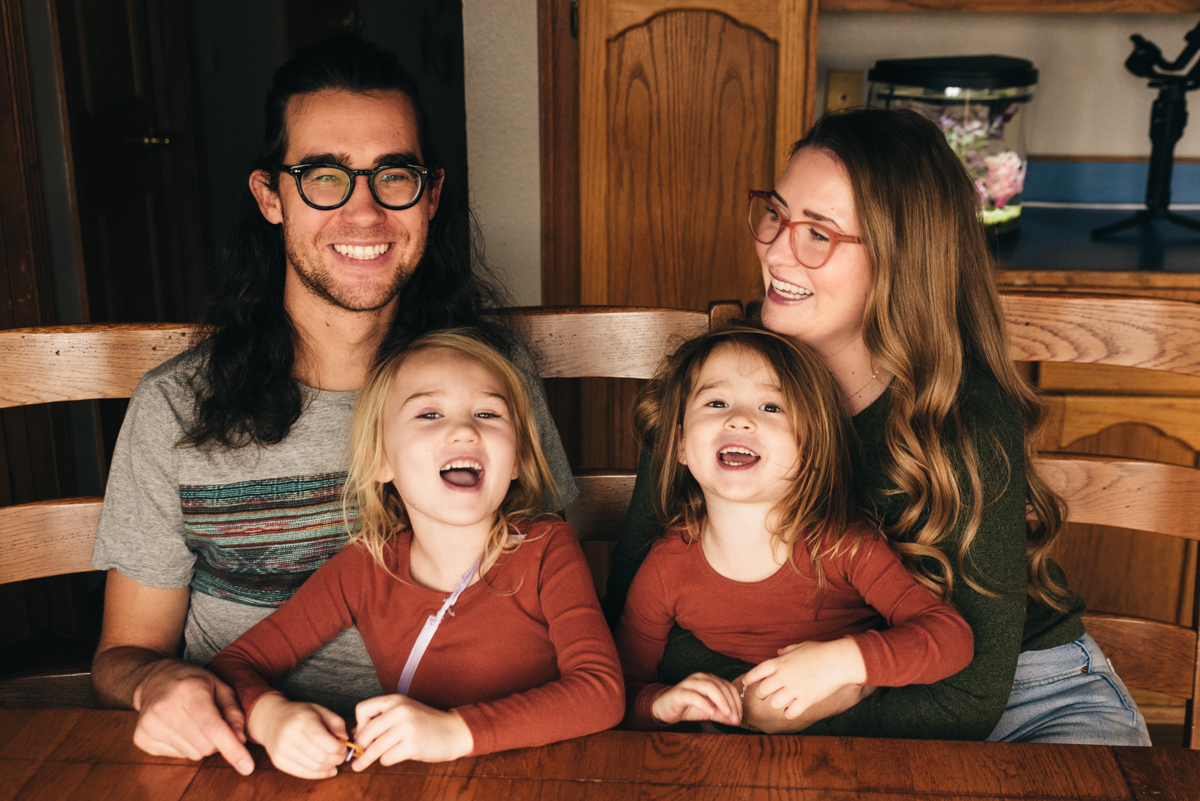 Family of four sits around kitchen table laughing during Flagstaff Family Film.