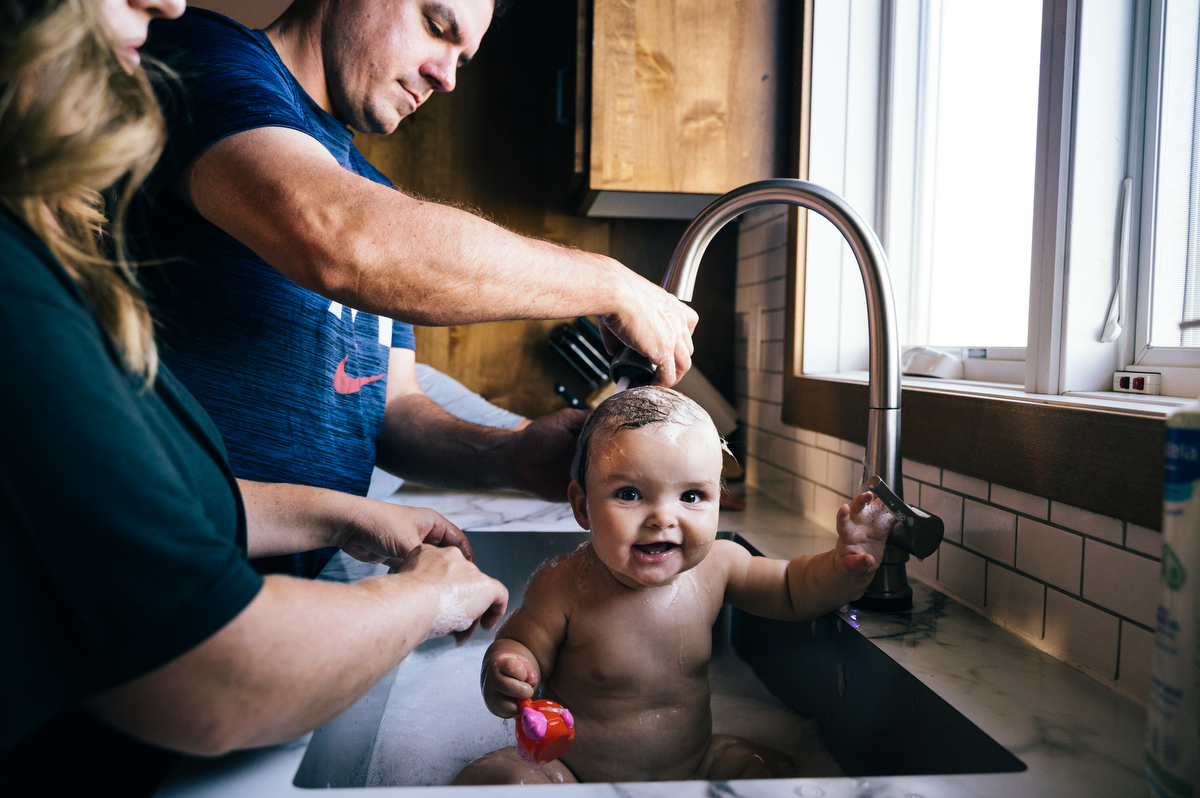 Toddler daughter gets bath in the sink during Northwest Minnesota family film.