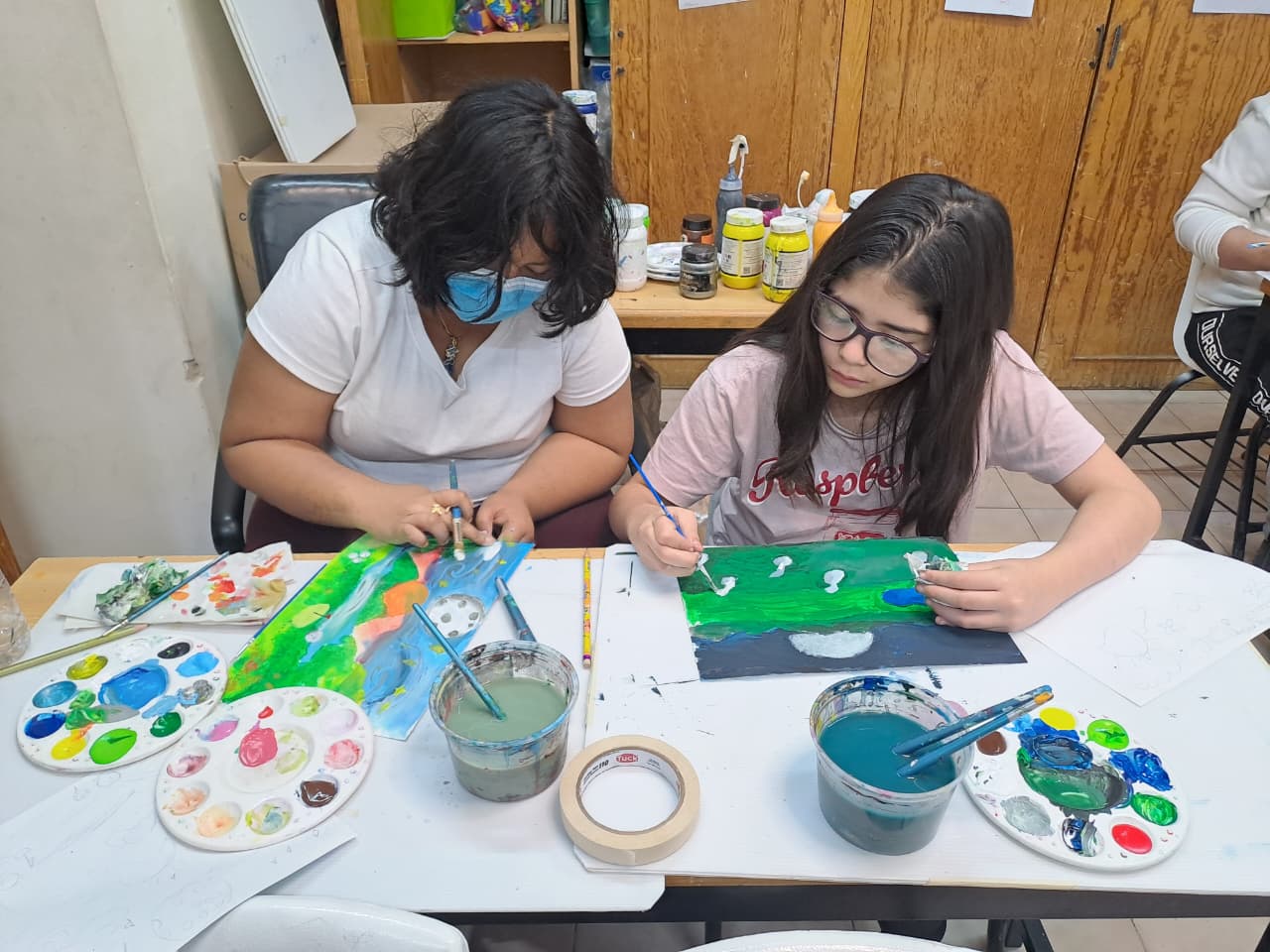 Niñas, niños y adolescentes de CANICA pintando en sesión previa al torneo, liderados por la maestra Lucero.
