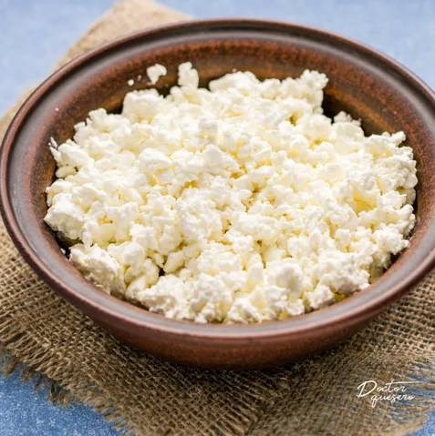 Comparison between cottage cheese and ricotta cheese on a wooden table.