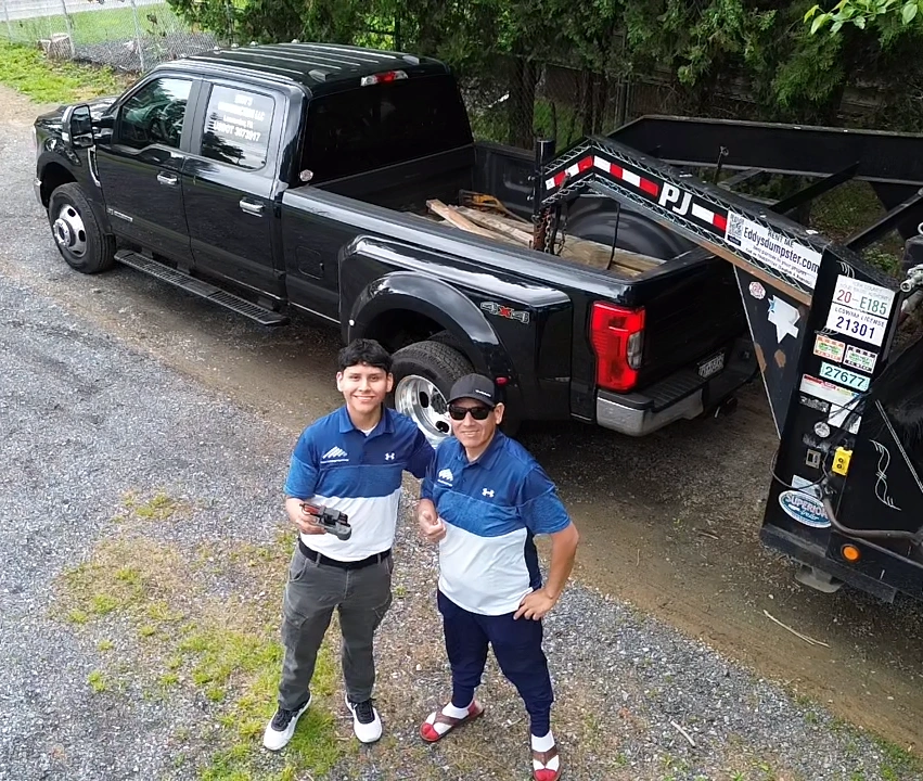 a father and a son with their dumpster truck