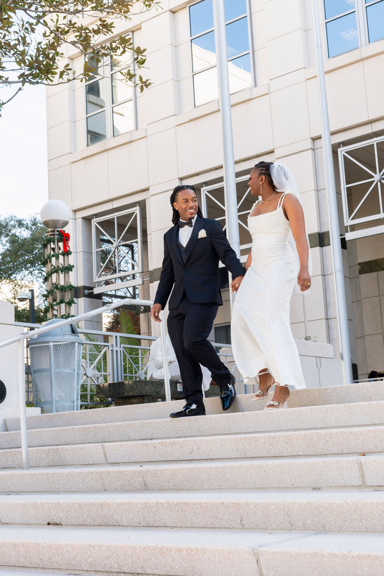 Just married couple walking down the steps of Orange County Courthouse in Orlando after elopement Just married couple walking down the steps of Orange County Courthouse in Orlando after elopement