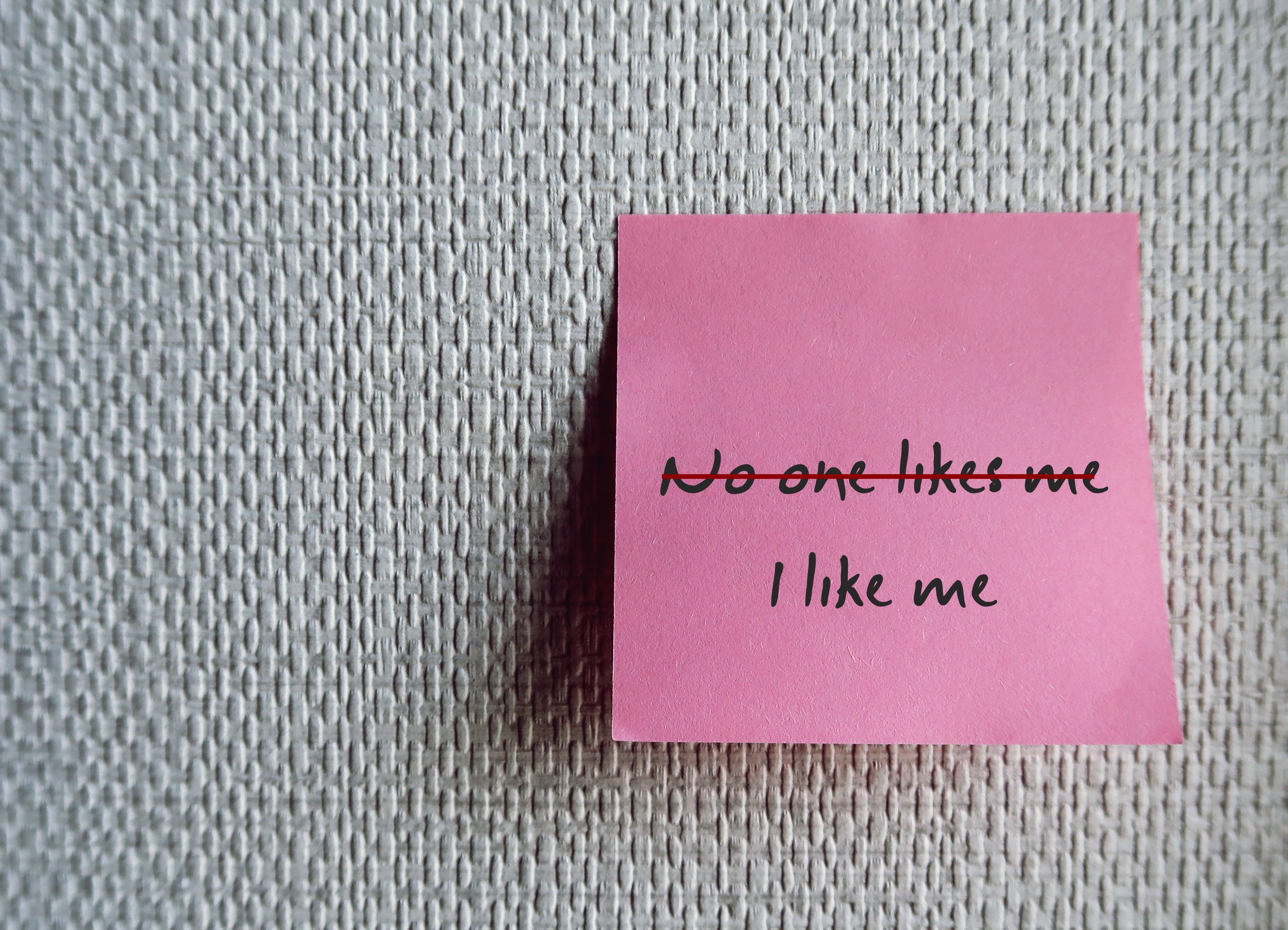 Pink post-it note on grey background with the words I like me Pink post-it note on grey background with the words I like me