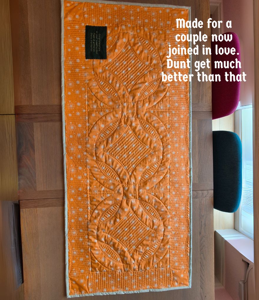 Back of double wedding ring quilt lying on a table, showing the digital and ruler quilting texture Back of double wedding ring quilt lying on a table, showing the digital and ruler quilting texture