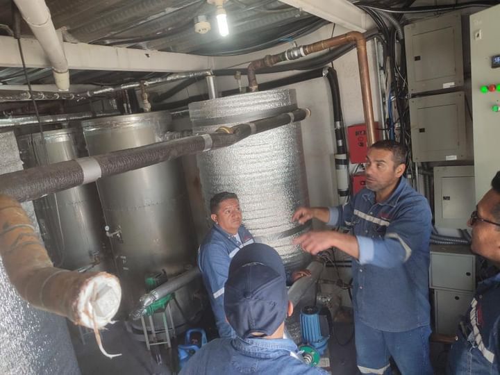 Experto analizando los componentes internos de un sistema de calderas complejo.