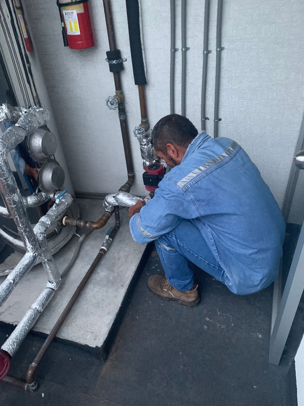 Técnico realizando mantenimiento preventivo en un sistema de climatización.