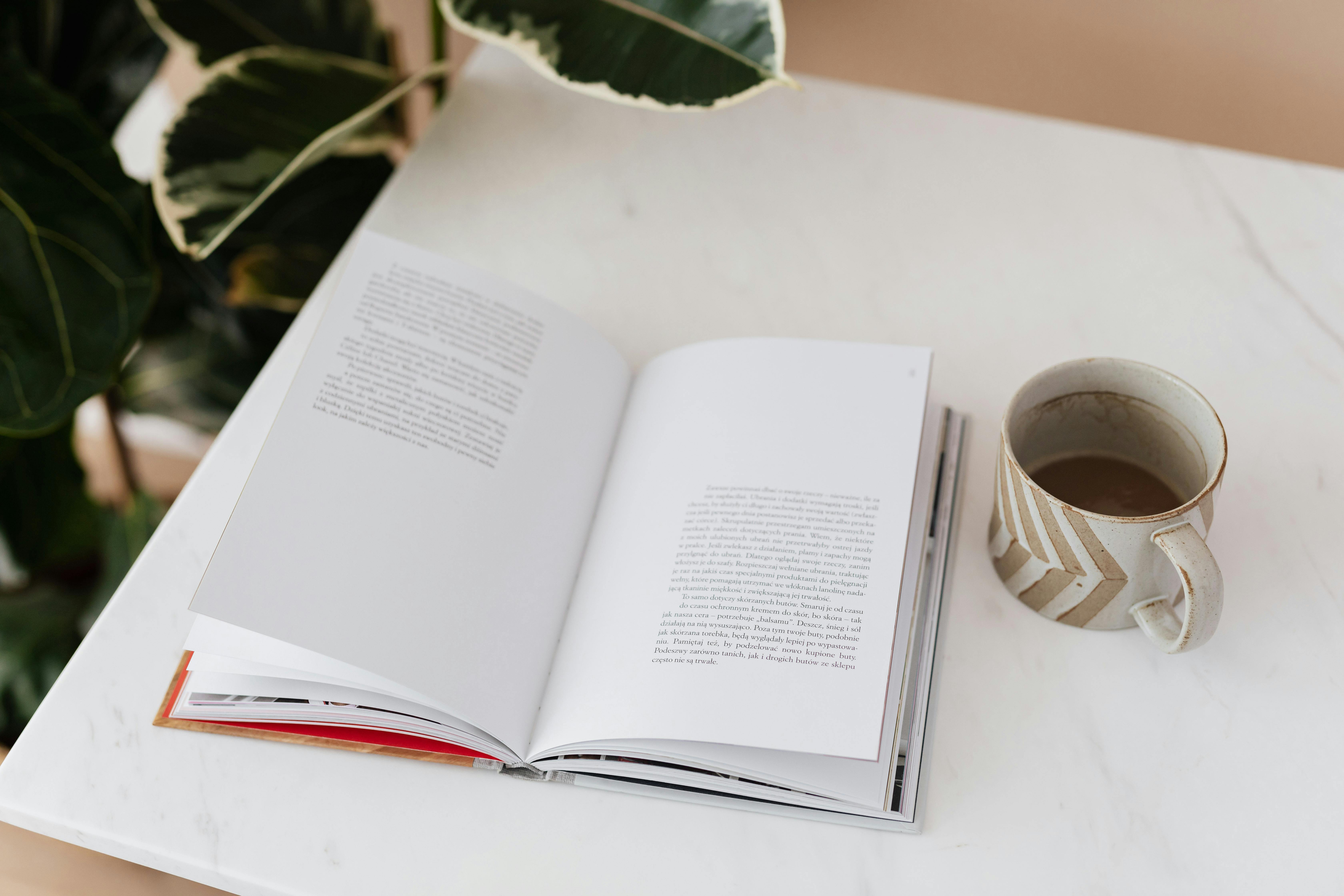 an image of an open book with coffee beside it an image of an open book with coffee beside it