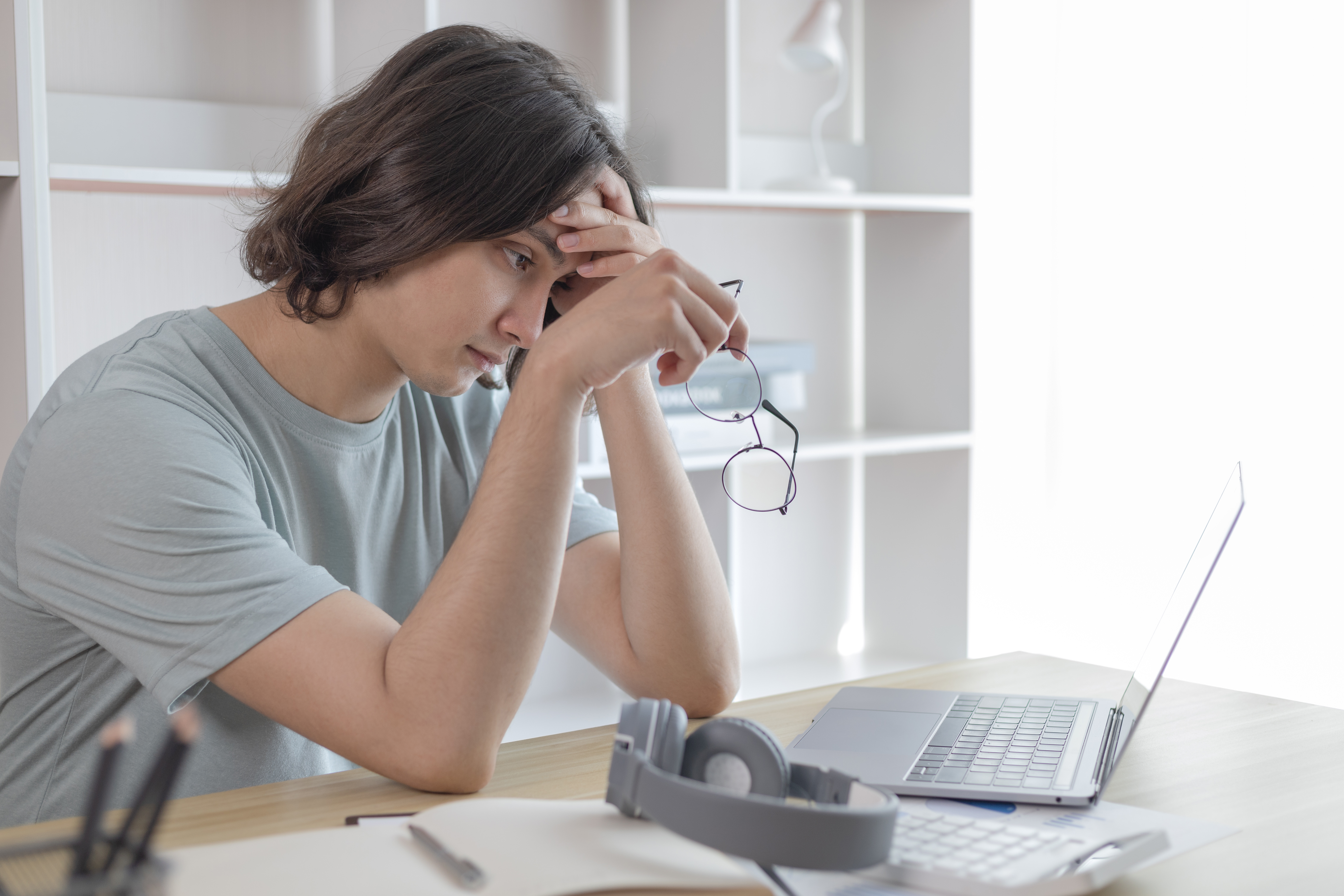 Frustrated writer sitting at a desk with a laptop, symbolizing common mistakes to avoid when writing an author bio. Frustrated writer sitting at a desk with a laptop, symbolizing common mistakes to avoid when writing an author bio.