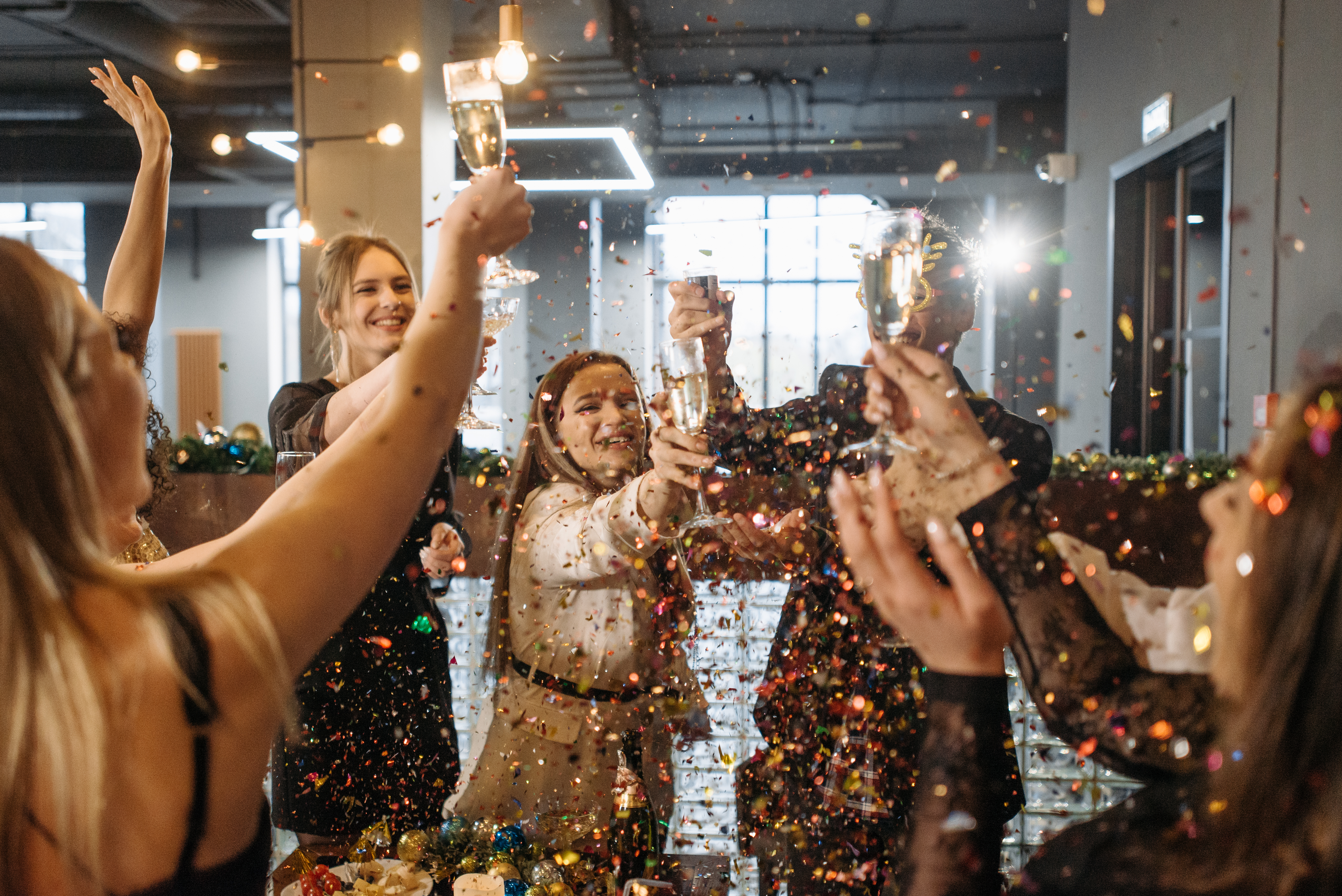 Group of people celebrating with champagne and confetti, symbolizing the excitement and joy of a book release party.