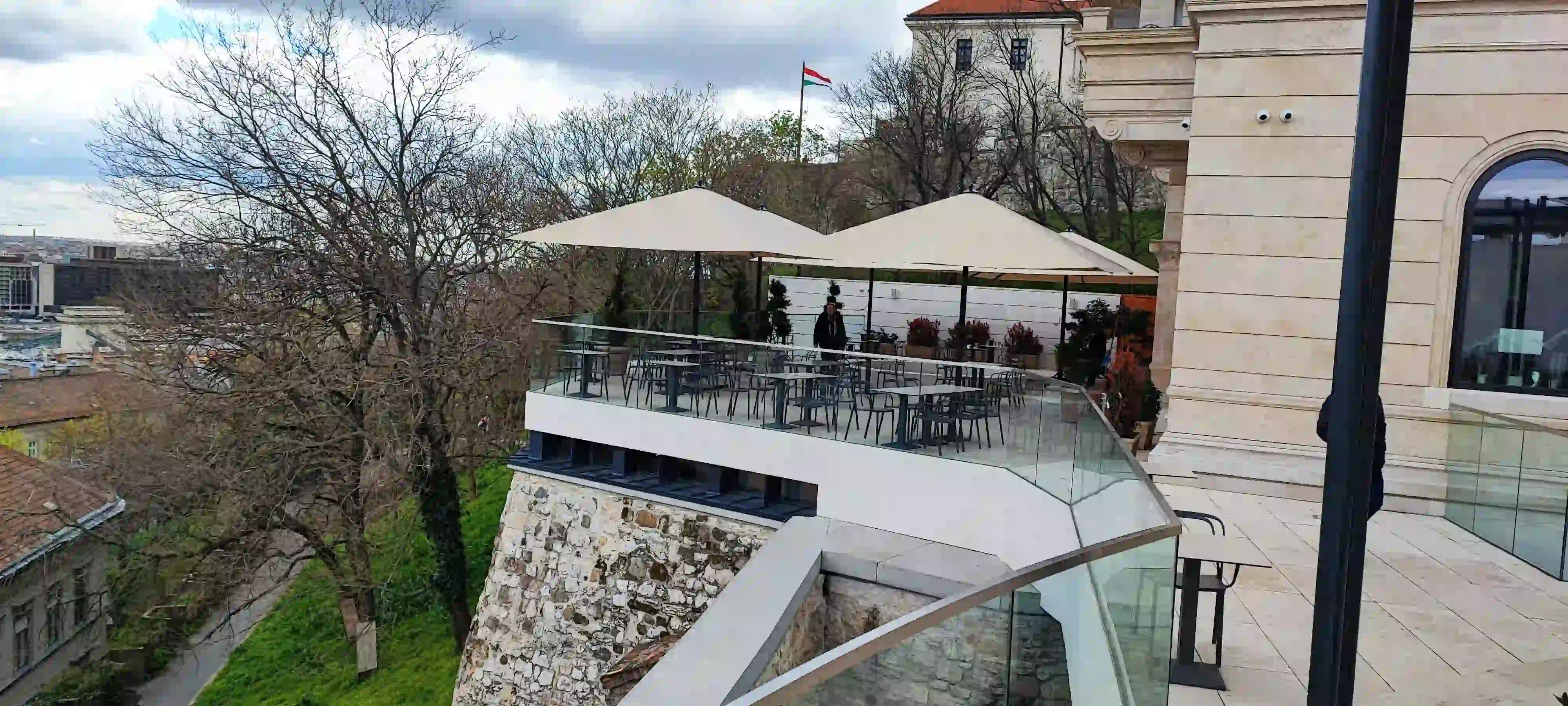 Étterem terasza nagy fehér napernyőkkel.