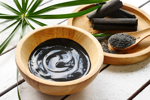 Activated charcoal powder and paste in wooden bowls used for detoxification and mycotoxin binding. Activated charcoal powder and paste in wooden bowls used for detoxification and mycotoxin binding.