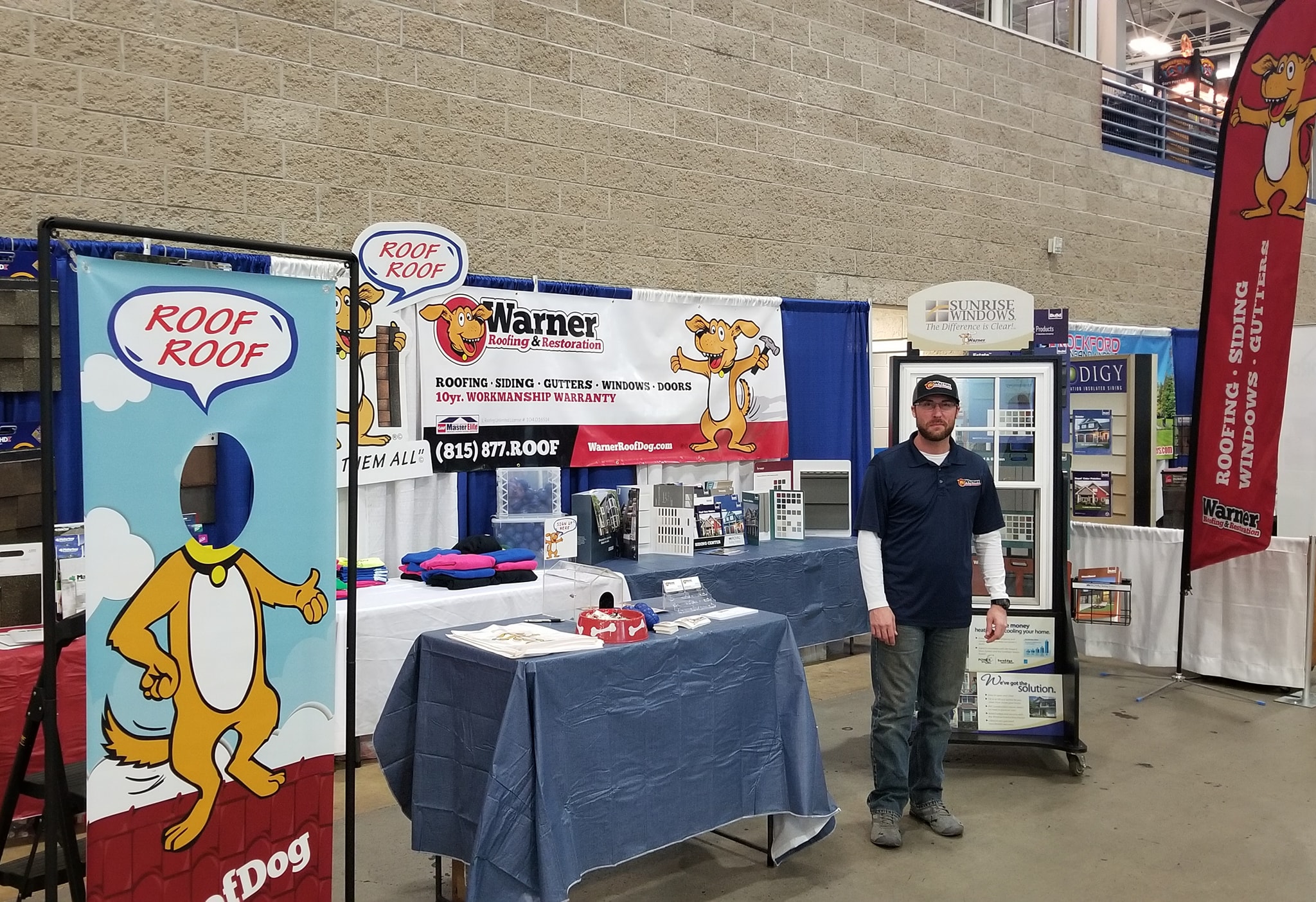 Warner Roofing & Restoration booth at the Rockford Home Show showcasing roofing, siding, and window services — trusted local roofer for over 14 years.