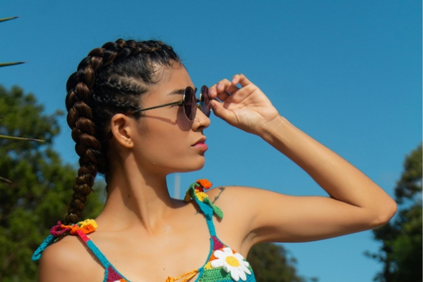 Frau mit dicken Goddess-Cornrows, die in offene, sanft gewellte Längen übergehen.