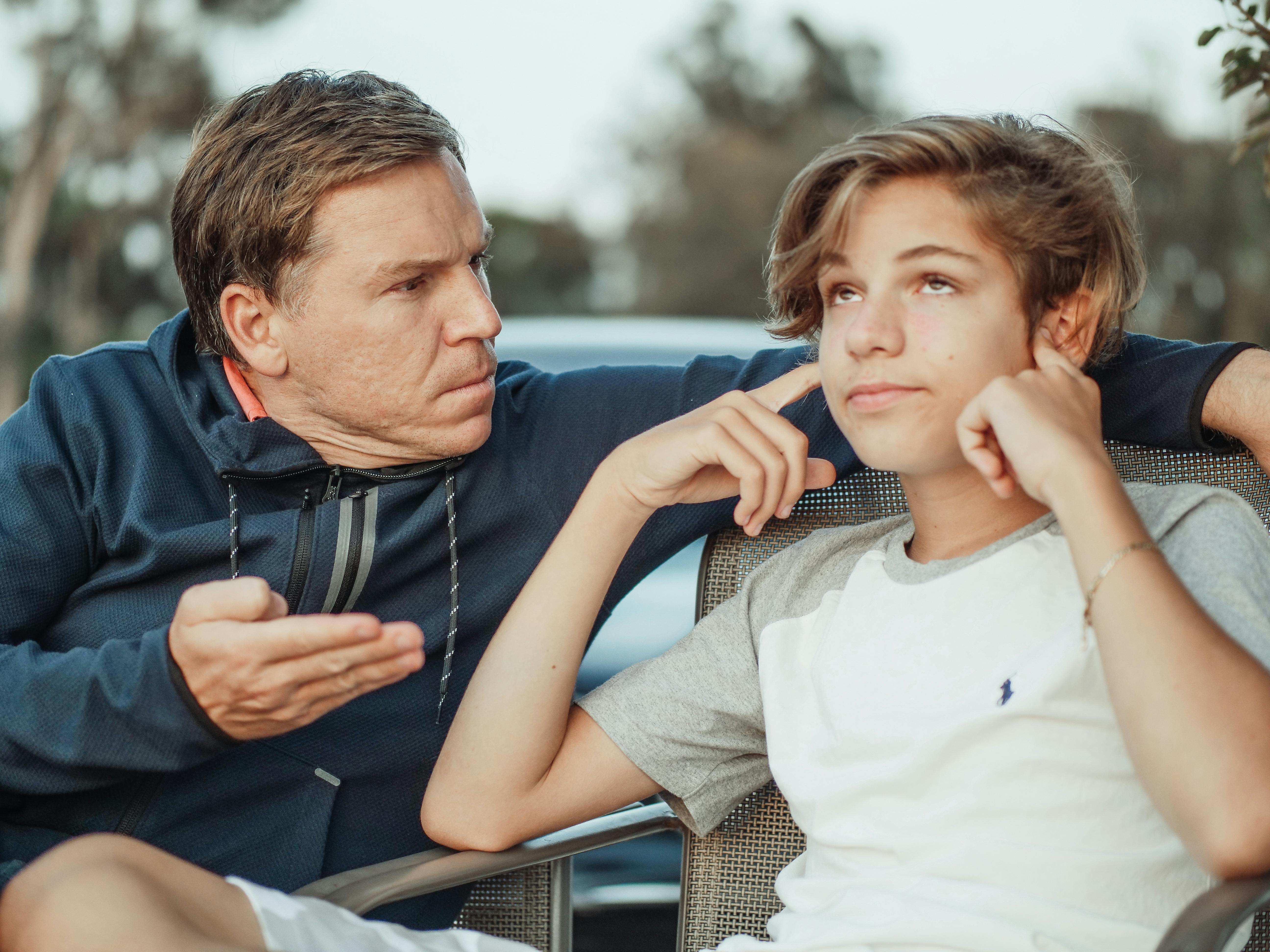 Father getting frustrated with his teenage son who is not listening to him