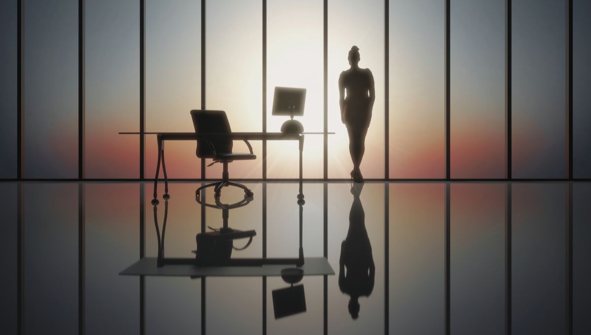 a business woman standing in the office, looking out over the view a business woman standing in the office, looking out over the view