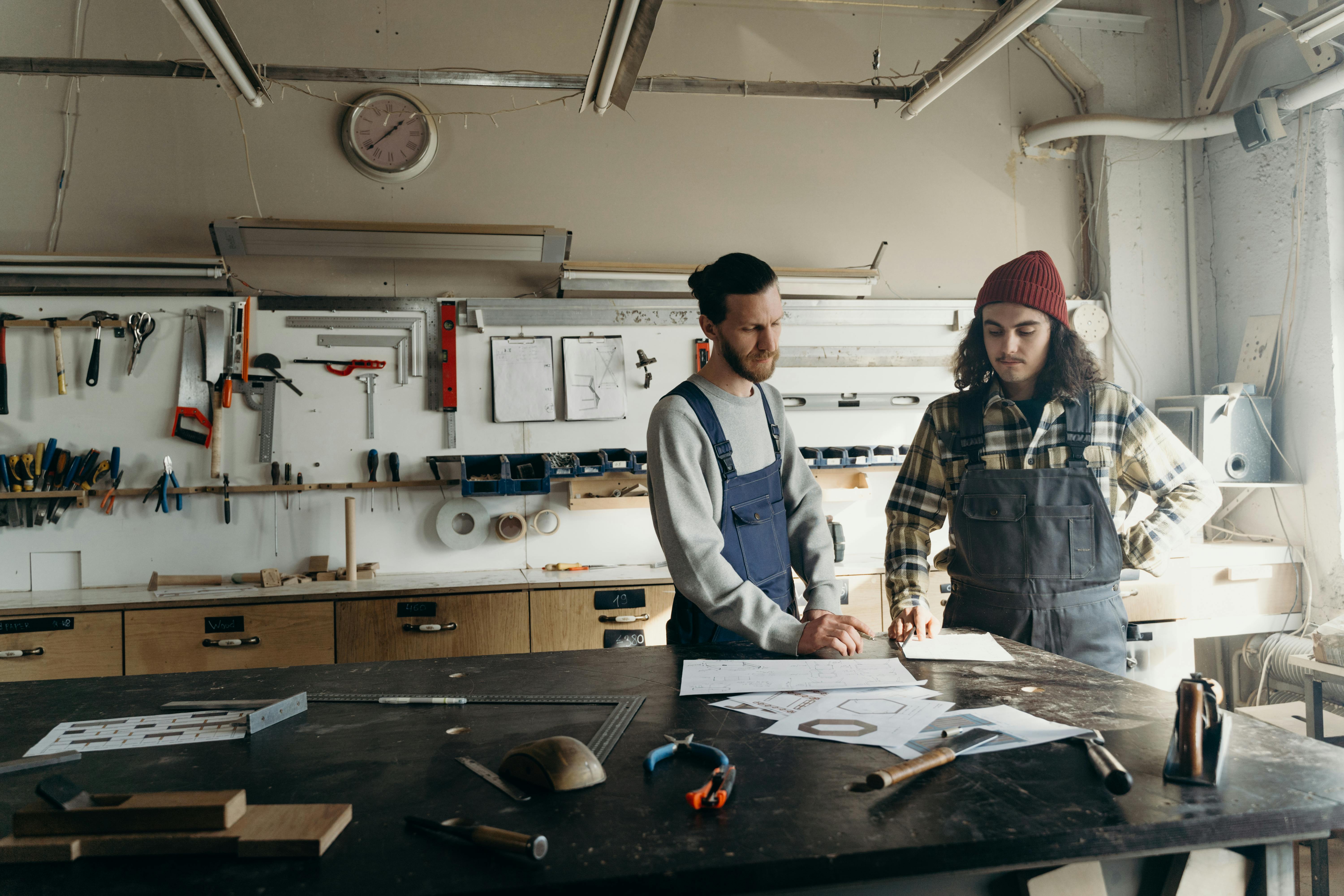 two men looking a building plans in a shed two men looking a building plans in a shed