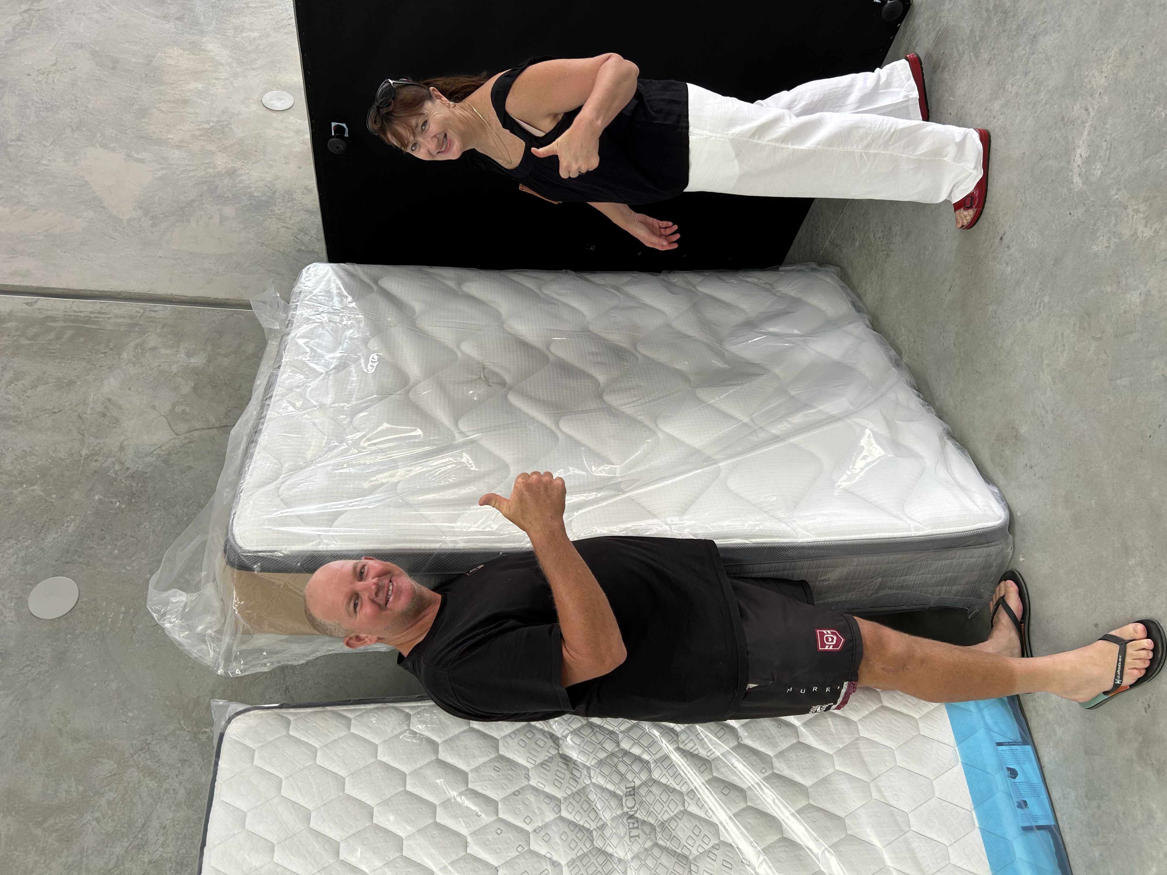 Customer testing mattress firmness at Mattress By Appointment Sunshine Coast showroom