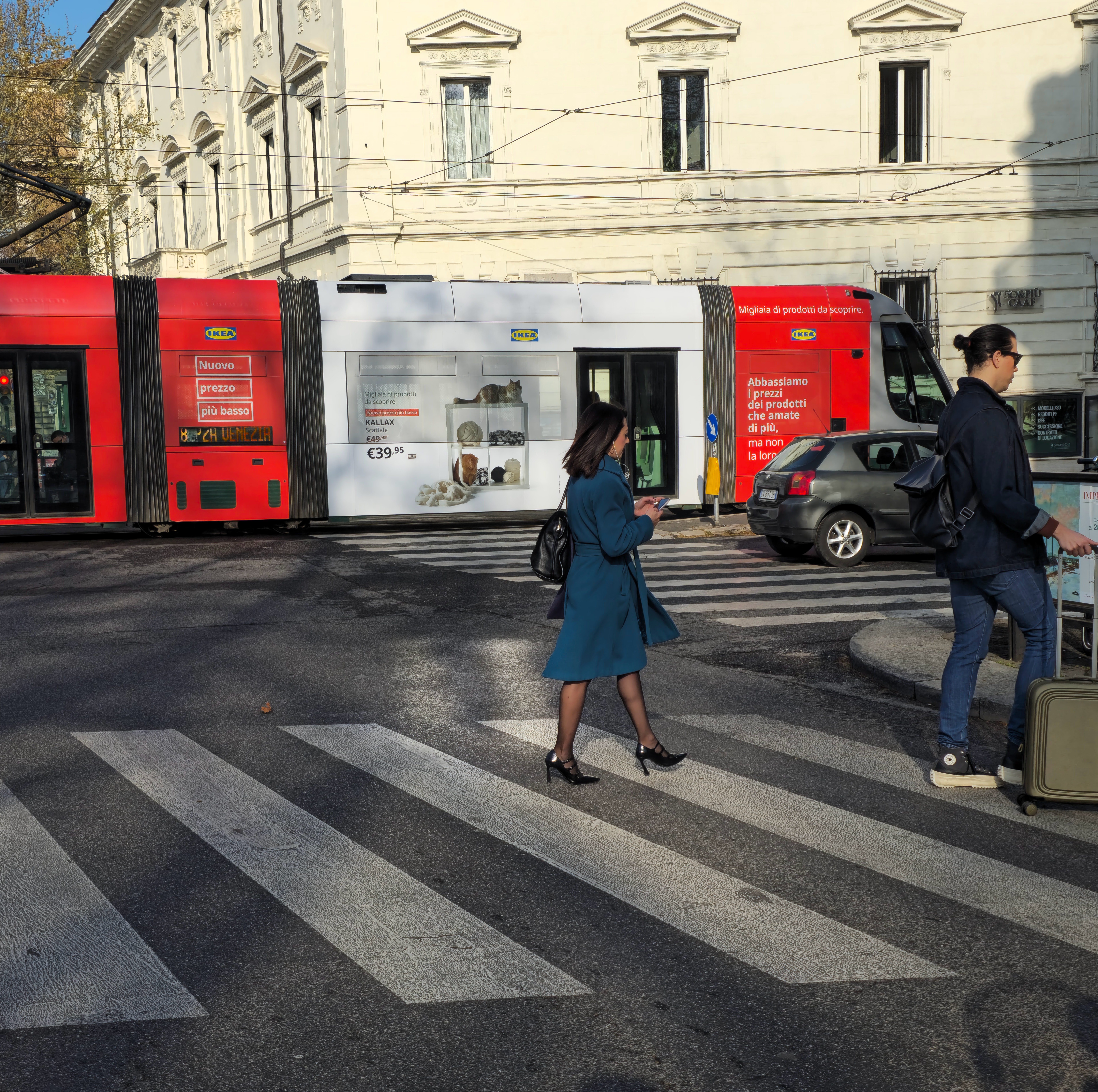 Una donna cammina sulle strisce con il telefono in mano pensado ad altro