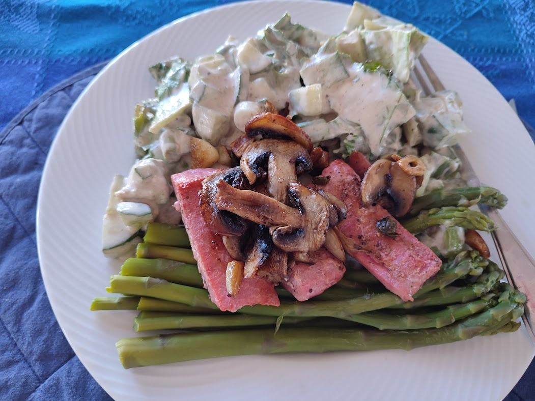Plate of keto-friendly meal with grilled asparagus, sautéed mushrooms, and a creamy potato salad. Plate of keto-friendly meal with grilled asparagus, sautéed mushrooms, and a creamy potato salad.