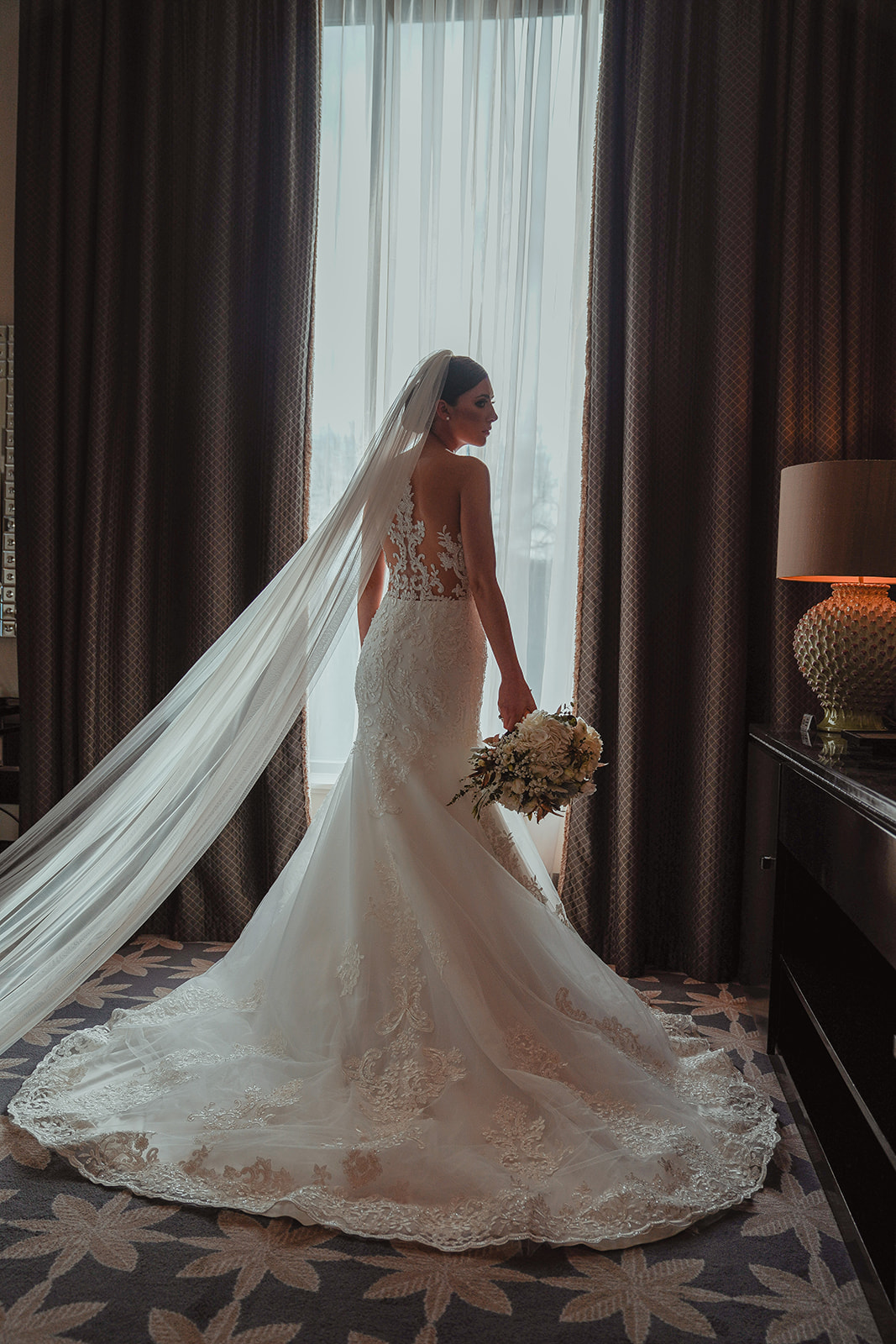 Bride in lace wedding dress by the window at Merchant hotel Belfast