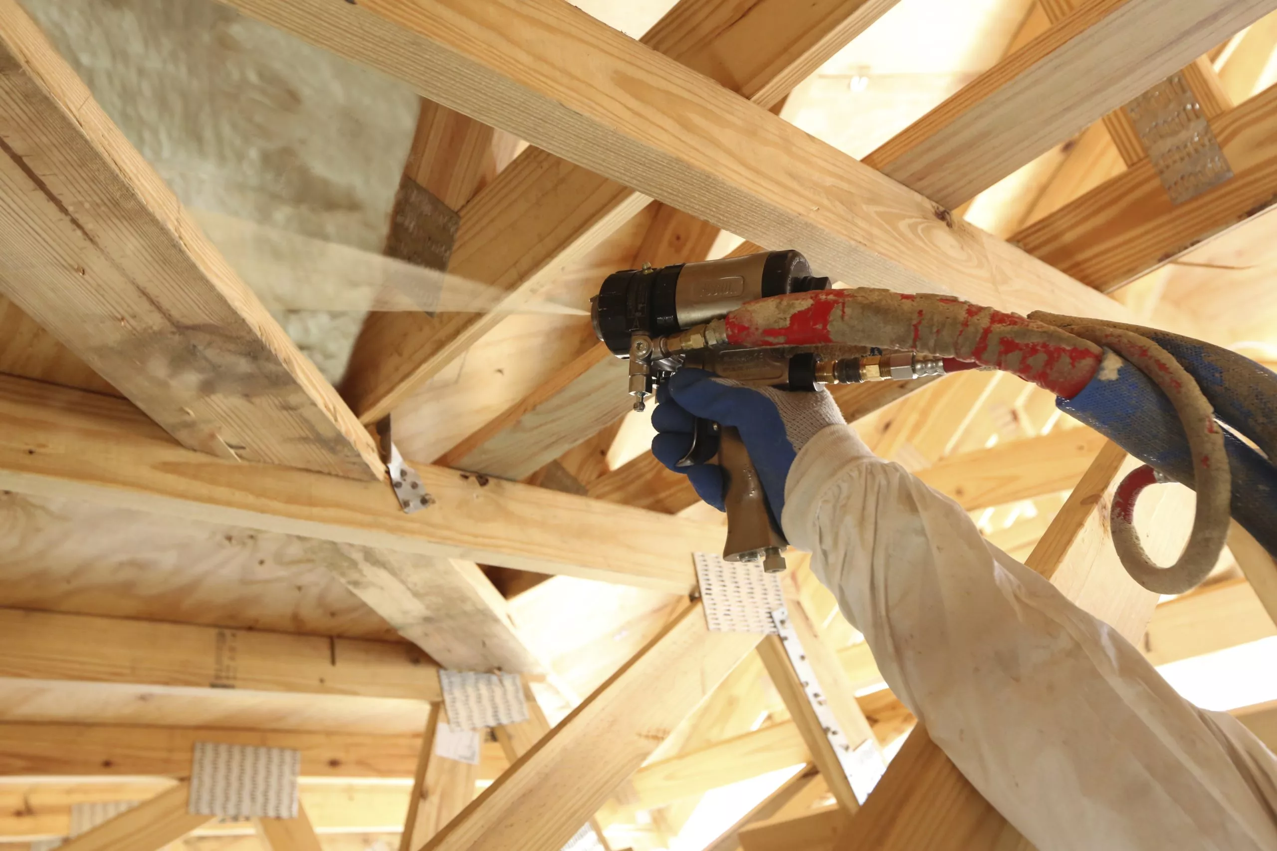 an expert roofing finishing the insulation on the attic