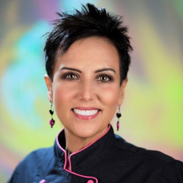 Photo of Chef AJ smiling with colorful background Photo of Chef AJ smiling with colorful background