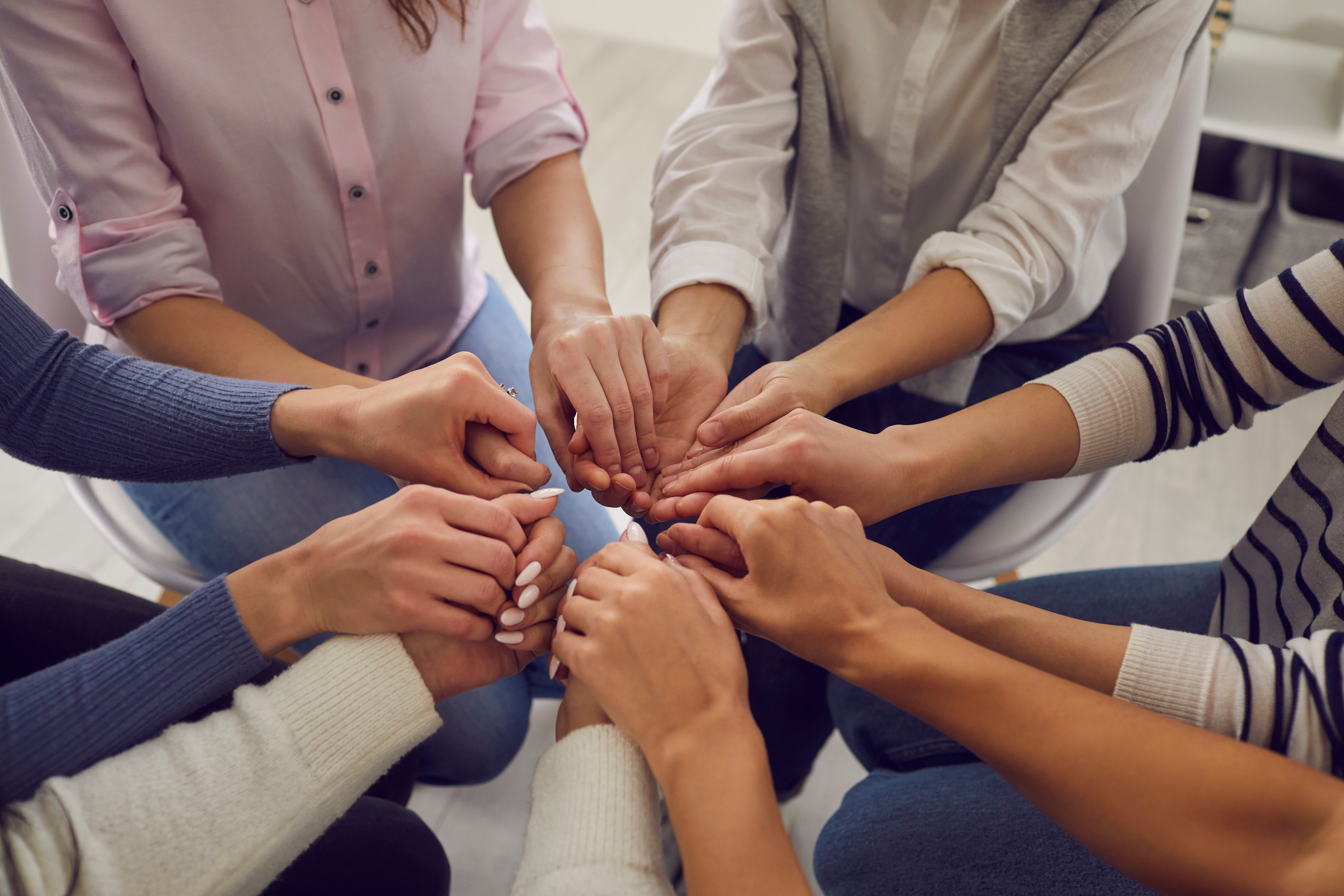 Support group holding hands in a circle showing unity, empathy, and emotional connection in a community setting Support group holding hands in a circle showing unity, empathy, and emotional connection in a community setting