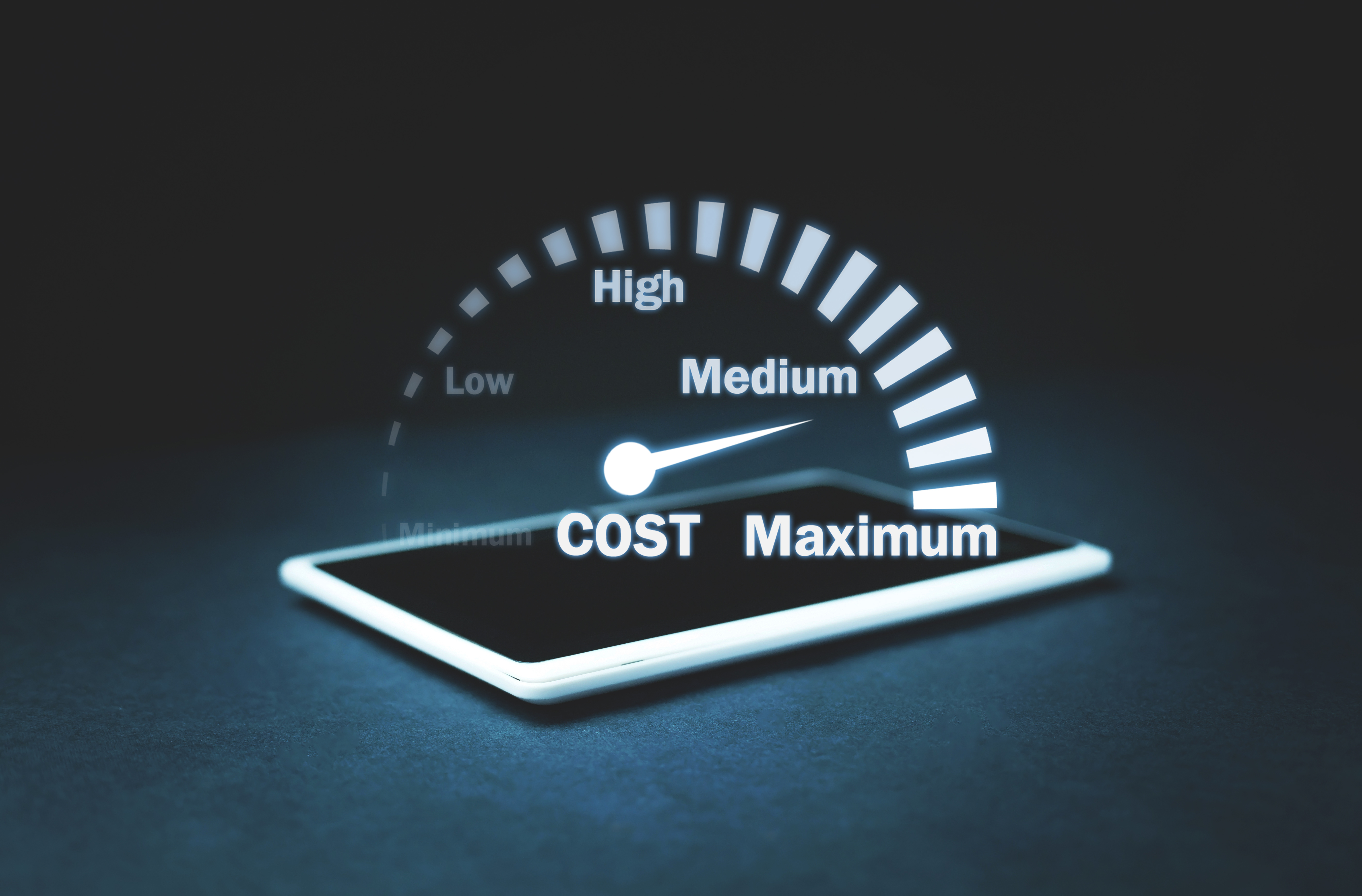 Digital concept image of a smartphone displaying a glowing cost gauge, with the needle pointing toward "Medium" on a scale ranging from "Minimum" to "Maximum." Digital concept image of a smartphone displaying a glowing cost gauge, with the needle pointing toward "Medium" on a scale ranging from "Minimum" to "Maximum."