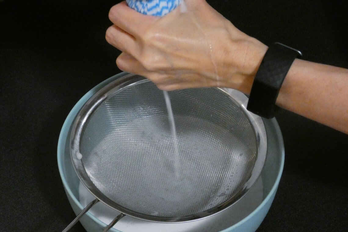 Making coconut milk from fresh coconut by squeezing through a muslin cloth Making coconut milk from fresh coconut by squeezing through a muslin cloth