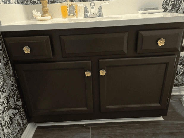 a newly painted bathroom vanity with floral knobs as part of an interior remodeling project.