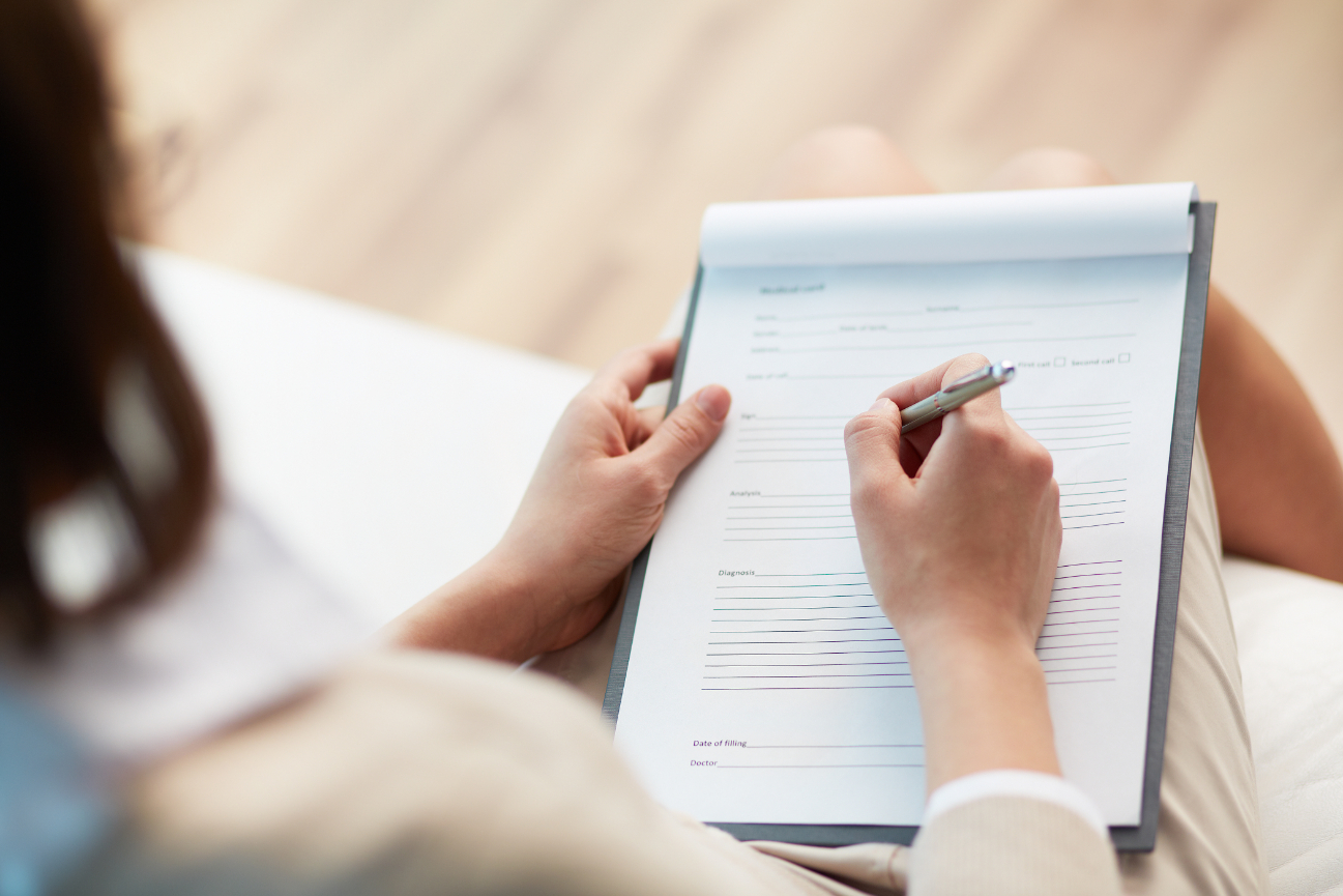 Female counselor writing down some information about her patients first therapy session