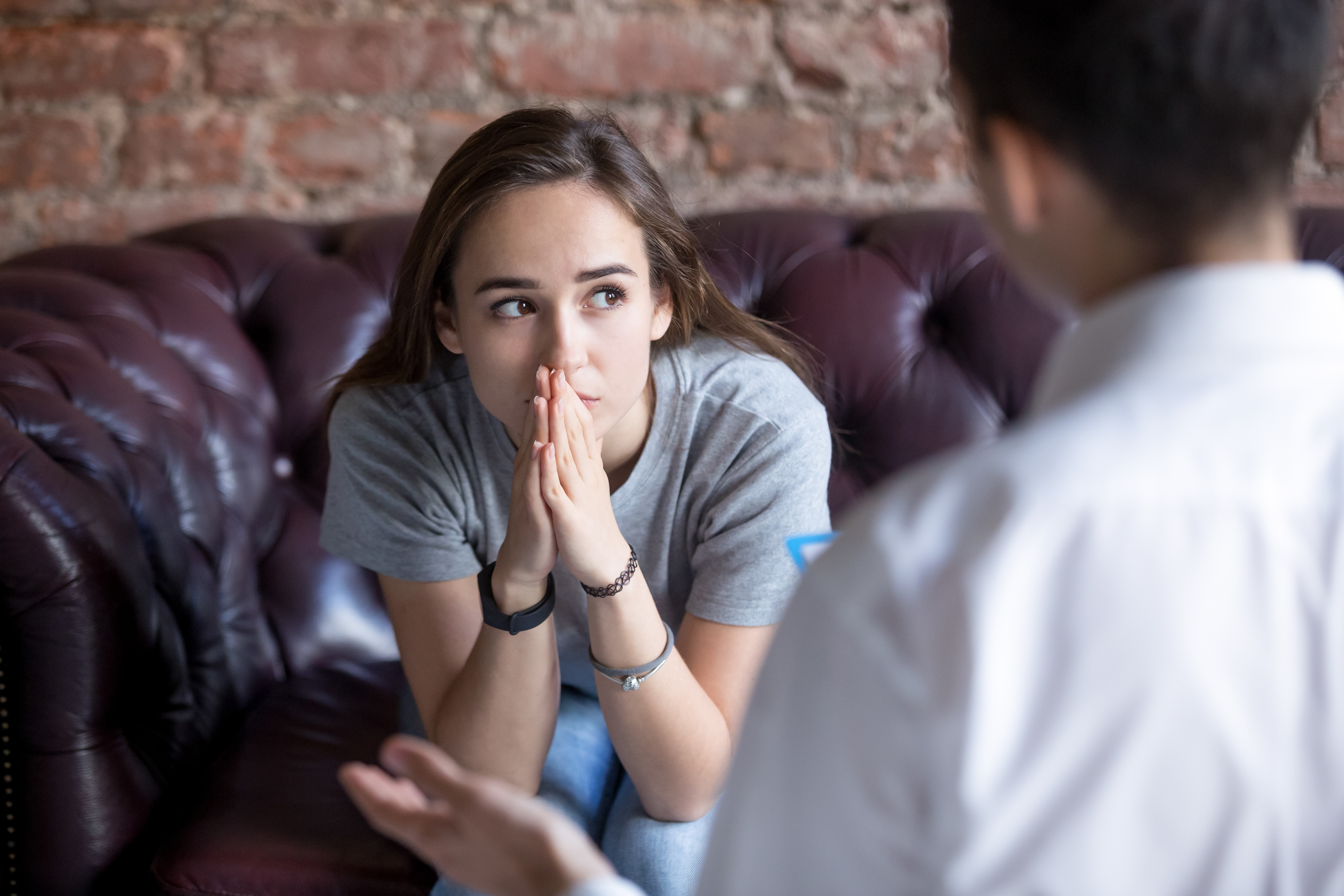 Unhappy young girl visiting at the psychologist