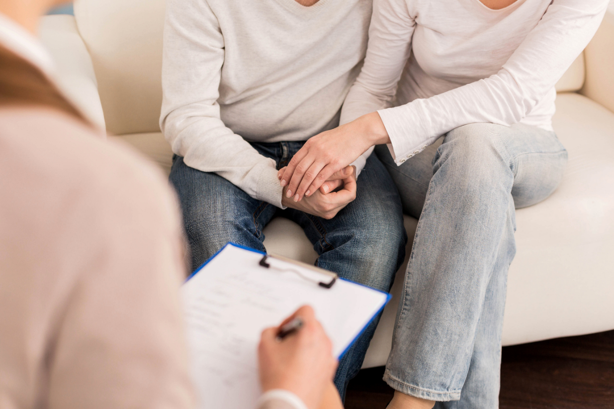 Pleasant nice couple holding hands during couples counseling 