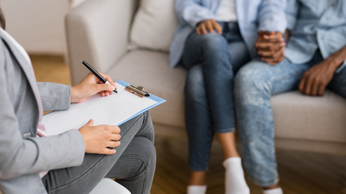 Couple holding hands on couch during couples counseling session