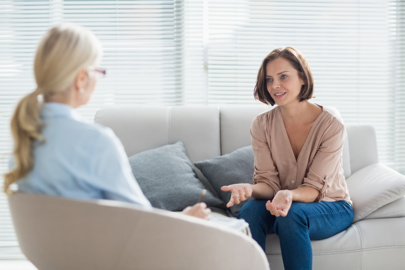 Woman speaks with her therapist o a couch