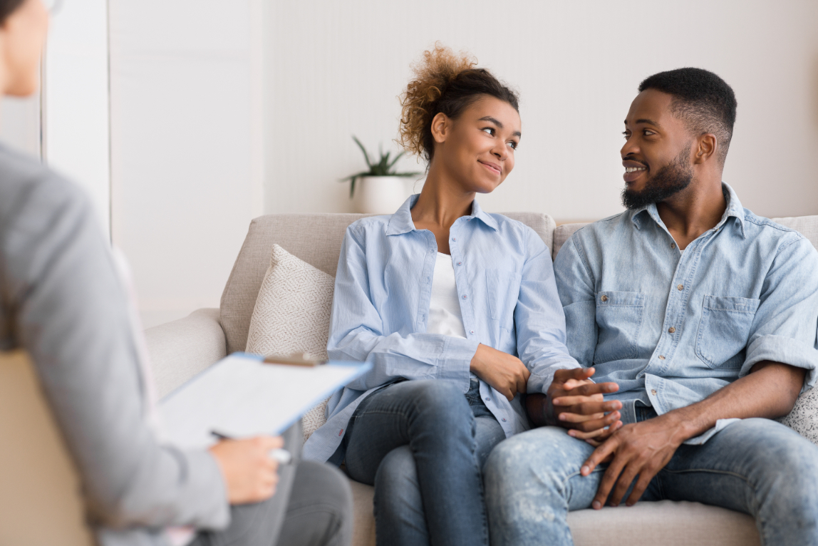 Couple sitting together and smiling during marriage counseling