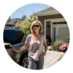 A photo of a happy woman with her new SUV, standing in her driveway